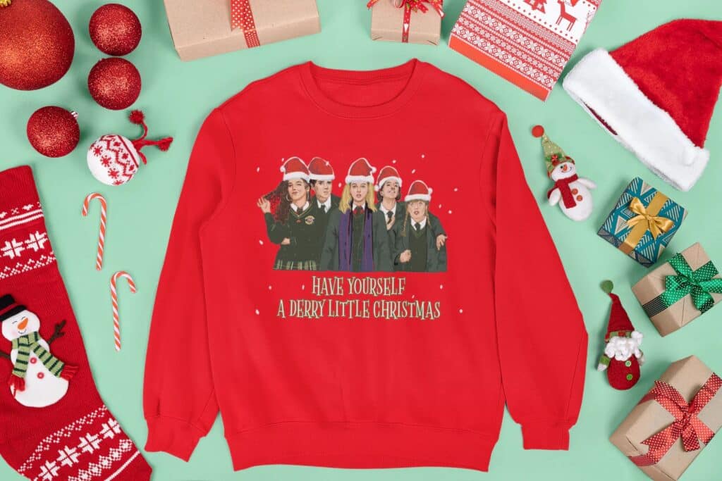 This jumper features the cast of Derry Girls wearing Santa hats with the words "Have yourself a Derry Little Christmas".