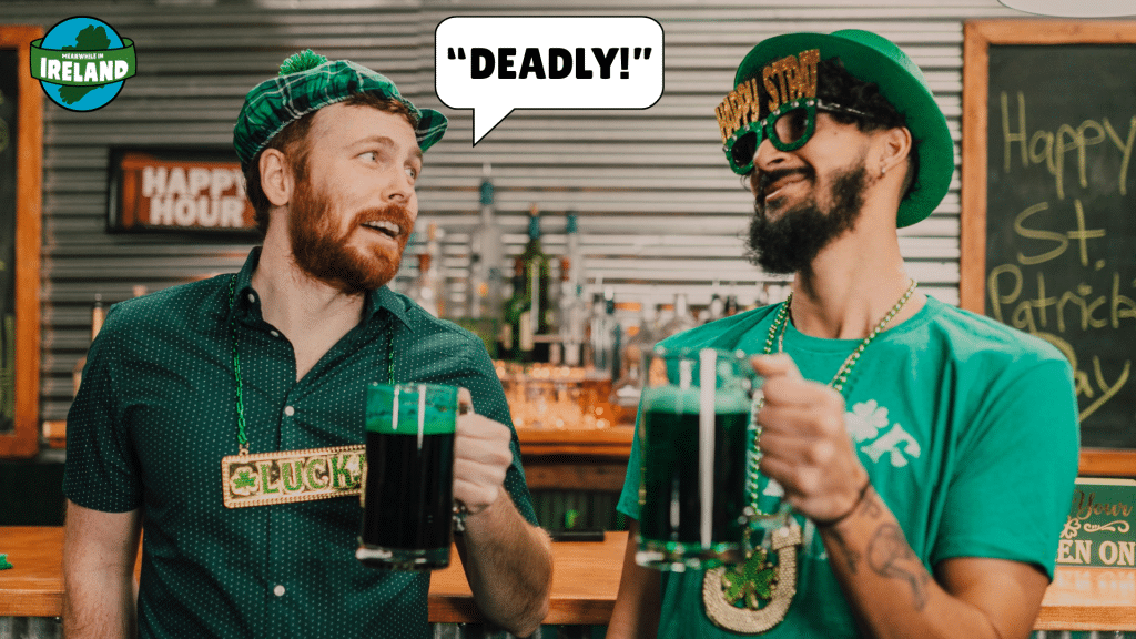 Two men in festive St. Patrick's Day gear stand at a bar holding mugs of green beer, with a speech bubble above one man that says, "DEADLY!"