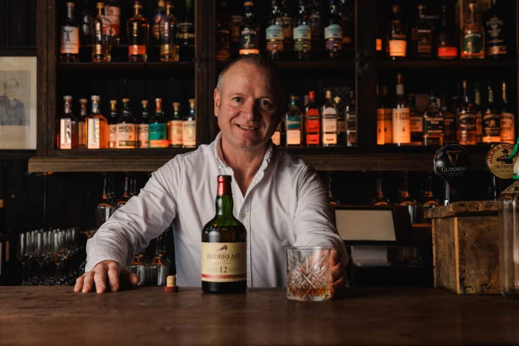 A bartender serving Red Breast.