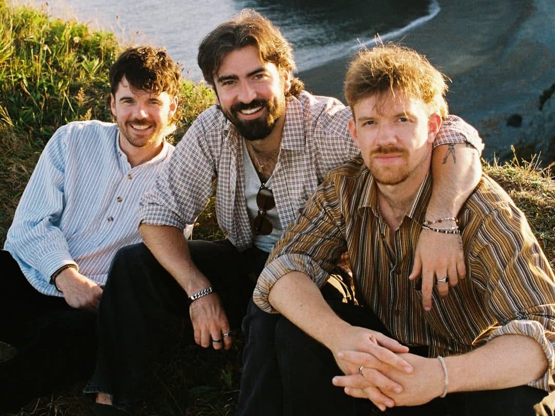 A group picture of the Irish band Amble with the backdrop of a beach.